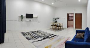 uma sala de estar com um sofá azul e uma televisão em FS Homestay Cherating em Kuantan