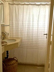 a bathroom with a sink and a shower curtain at Cálido monoambiente con cochera en Yerba Buena in Yerba Buena
