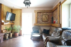 sala de estar con sofás de cuero y TV en Bociani domek u Barbary en Giże