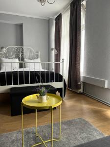 a bedroom with a bed and a yellow table at ArtMotel & Bistro in Haţeg