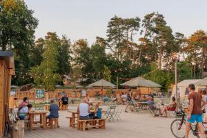 a group of people sitting at tables in a park at Huttopia De Meinweg in Herkenbosch
