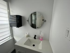 a white bathroom with a sink and a mirror at Auberge Lac-Saint-Jean in Roberval +21 photos