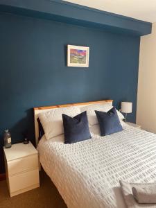 ein blaues Schlafzimmer mit einem Bett mit blauen Wänden in der Unterkunft Waverley Court in Fort William