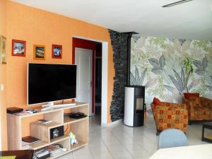 sala de estar con TV de pantalla plana en la pared en Villa de 3 chambres avec piscine privee jardin amenage et wifi a Kersaint Plabennec, en Kersaint-Plabennec