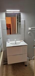 a bathroom with a white sink and a mirror at Appartement Saint Lary - pla d'adet - aux pieds des pistes in Saint-Lary-Soulan +4 photos