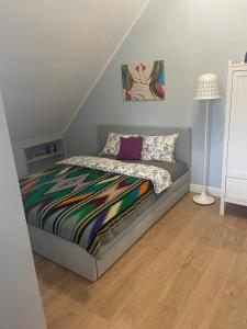 a bed with a colorful blanket on it in a room at Apartamet Gabriel in Tykocin