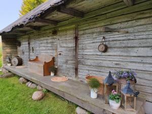 una cabaña de madera con plantas a un lado en Supa talu kodumajutus 100 a vanuses aidas - avatud suvehooajal - open in summer 