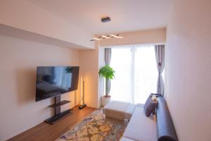 sala de estar con sofá y TV de pantalla plana en NEW OPEN City View Suite in Minami-Azabu en Tokio