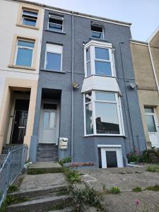 a gray house with a white door and windows at Lovely Apartment in Swansea in Swansea
