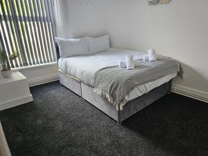 a bedroom with a bed with two towels on it at Lovely Apartment in Swansea in Swansea