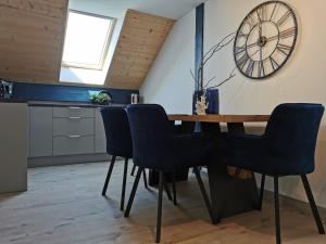 una sala da pranzo con tavolo in legno e sedie blu di Apartamenty PRZYSTAŃ Chłopy a Chłopy