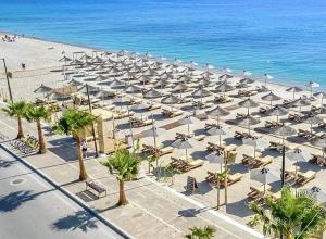 a beach with many umbrellas and chairs and the ocean at Mariangelas House in Kos