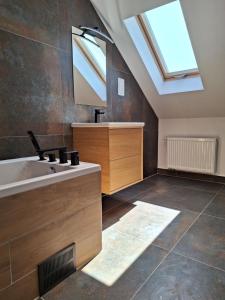 a bathroom with a sink and a skylight at Apartamenty PRZYSTAŃ Chłopy in Chłopy