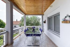 een patio met een tafel en stoelen op een balkon bij Villa Fabiola in Vergia