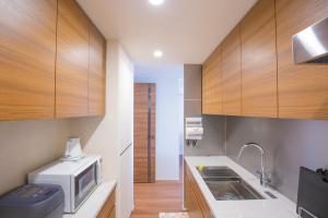 a kitchen with wooden cabinets and a microwave at NEW OPEN City View Suite in Minami-Azabu in Tokyo