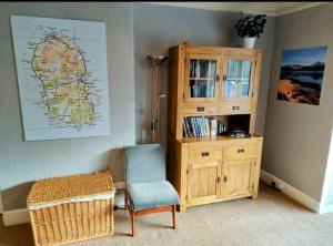 Habitación con silla y armario de madera. en Allandale House en Brodick