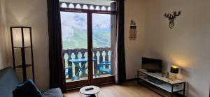 a living room with a large window with a view at Appartement Saint Lary - pla d'adet - aux pieds des pistes in Saint-Lary-Soulan