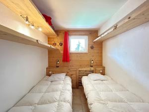 a room with two beds in it with a window at Appartement de charme au pied des pistes, centre des Gets, balcon et terrasse, 2 chambres, Wi-Fi gratuit - FR-1-623-268 in Les Gets