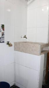 uma casa de banho com um lavatório e paredes em azulejos brancos em Aparta Suite Torre De Prado 501 em Medellín