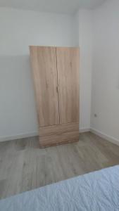 um quarto com um armário de madeira no canto em Apartamentos NayDa N4 de 2 habitaciones em Mérida
