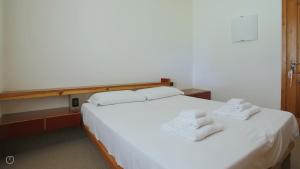 ein Schlafzimmer mit einem weißen Bett mit Handtüchern darauf in der Unterkunft Italianway - San Rocco 73 in San Fedele Intelvi + 63 Fotos