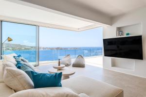 a living room with a large tv and a large window at Villa Lilium II in Psarou