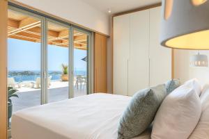 a bedroom with a bed with a view of the ocean at Villa Lilium II in Psarou