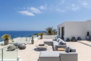 a patio with couches and a view of the ocean at Villa Lilium II in Psarou