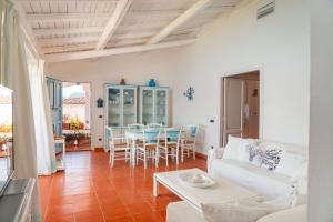 een woonkamer met een witte bank en een tafel bij Casa Azzurra con Terrazza Vista Mare by Wonderful Italy in Golfo Aranci