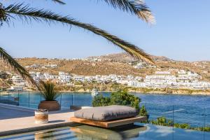 a swimming pool with a bed and a view of the water at Villa Lilium II - Sanctuary overlooking Psarou Bay in Psarou +68 photos