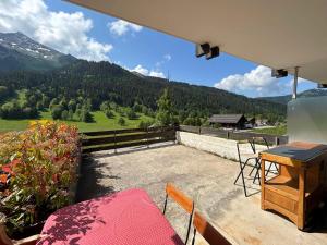 a patio with a table and chairs and a view of a mountain at Charmant studio rénové à La Clusaz - 4 pers, terrasse, parking - FR-1-437-102 in La Clusaz