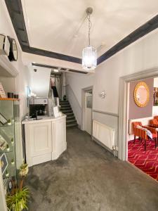 a room with a staircase with chairs and a table at The Broadway Hotel in Llandudno