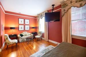 a bedroom with orange walls and a bed and a table and chairs at Charming Durham Studio Steps Away from Duke in Durham