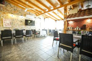 jadalnia ze stołami i krzesłami oraz kamienną ścianą w obiekcie Pool Apartments Julia w mieście Zadar