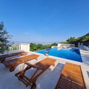 a patio with two picnic tables and a swimming pool at Sea view Luxury Hotel Villa Conte with private swiming pool and romantic SPA in Podstrana