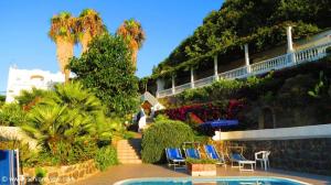 a resort with a pool and chairs and palm trees at Hotel Parco Conte in Casamicciola Terme
