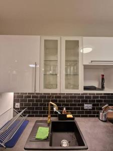 a kitchen with a sink and a counter top at Magnifique Appartement Paris La Défense in Colombes