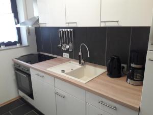 a kitchen with a sink and a black wall at Urlaub und Wellness im Fichtelgebirge in Warmensteinach