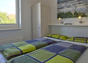 ヴァンガーオーゲにあるResidenz am Rosengarten 3 - Familienfreundliche, moderne Maisonettenwohnungのベッドルーム1室(ベッド2台、窓付)