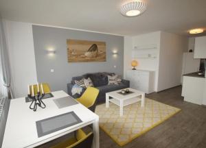 un salon avec un canapé et une table dans l'établissement WoogeBella - Traumblick auf die Nordsee, à Wangerooge