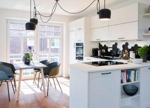 a kitchen with white cabinets and a table and chairs at Miss Evans macht blau in Wangerooge