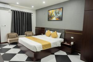 ein Hotelzimmer mit einem Bett und einem Stuhl in der Unterkunft Anh Anh Luxury Hotel in Tuyên Quang