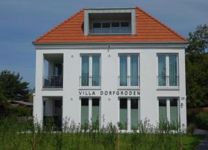 ヴァンガーオーゲにあるLüttje Oog - Moderner und behaglicher Komfort für 4 Personen auf 59 m²の赤屋根白い建物