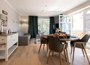 uma cozinha e sala de estar com mesa e cadeiras em Lindenhof- Silbermöwe em Wangerooge