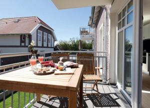 einen Holztisch auf dem Balkon eines Hauses in der Unterkunft Lindenhof- Silbermöwe in Wangerooge