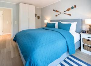 Una cama azul y blanca en un dormitorio en Lindenhof- Silbermöwe, en Wangerooge