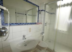 ヴァンガーオーゲにあるFerienwohnung 7 Rosenzweigの白いバスルーム(シンク、シャワー付)