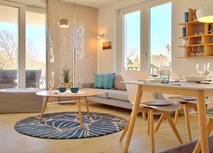 ein Wohnzimmer mit einem Tisch und einem Sofa in der Unterkunft Strandlust - Anspruchsvolle Ferienwohnung in Wangerooge