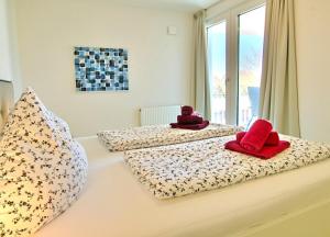 ヴァンガーオーゲにあるStrandlust - Anspruchsvolle Ferienwohnungのベッドルーム1室(赤いタオル付きのベッド2台付)