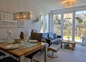 ヴァンガーオーゲにあるStrandperle; idyllisch gelegen mit Terrasse und Garten, für 4 Personenのリビングルーム(テーブル、青いソファ付)